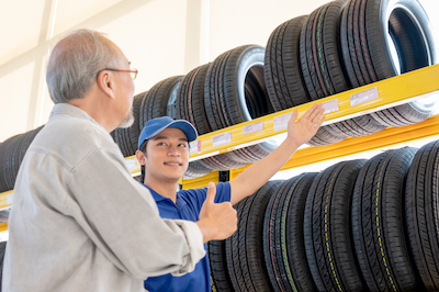 car mechanic helping customer buy new tires